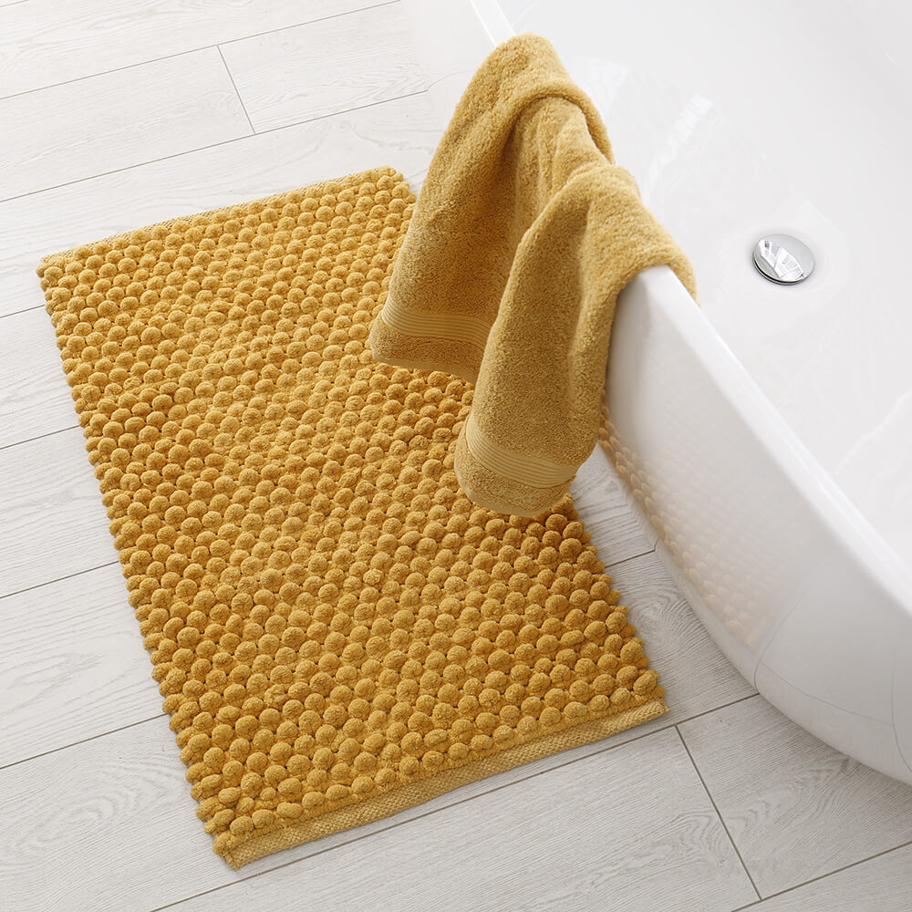 A bathroom with yellow bathroom textiles